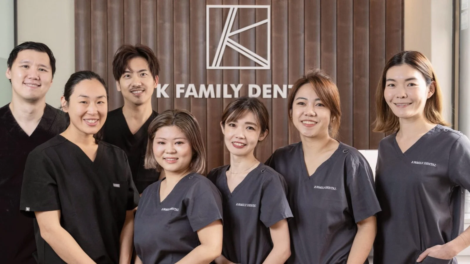 K Family Dental - Caring dentist helping a child learn proper brushing technique